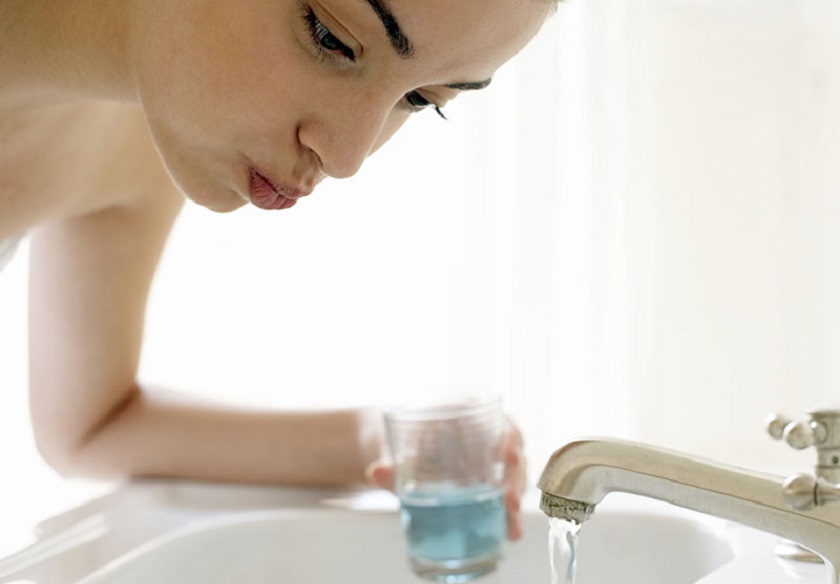 Súc miệng hàng ngày với nước muối sinh lý để làm sạch khoang miệng sau khi nhổ răng khôn
