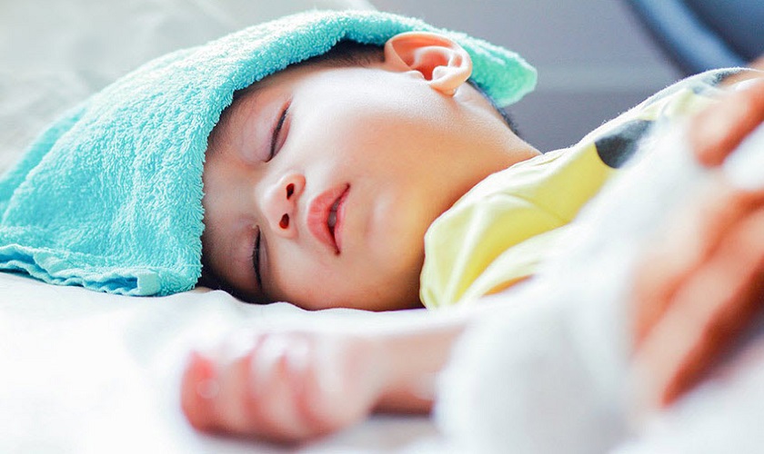 Đắp khăn lạnh để giúp trẻ hạ sốt khi mọc răng